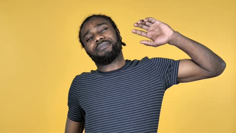 Casual-African-Man-Yawning-and-Stretching-BodyIsolated-on-Yellow-Background
