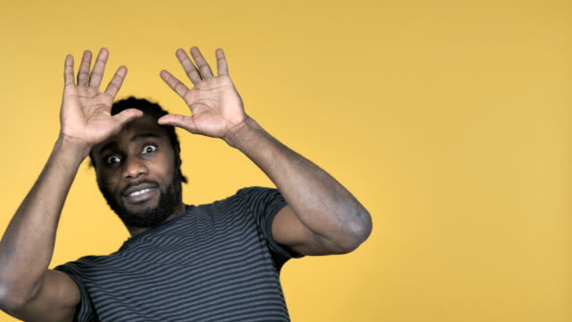 Casual-African-Man-Confused-and-Scared-of-Problems-Isolated-on-Yellow-Background