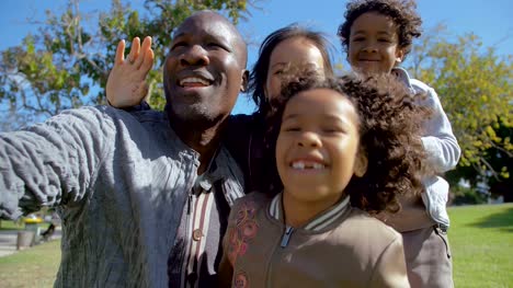 Familia-multicultural-agitar-y-hacer-video-llamada-juntos-en-el-Parque