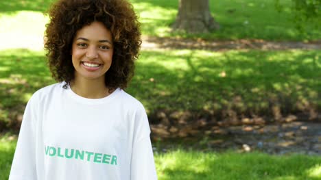 Pretty-volunteer-smiling-at-the-camera-and-pointing-to-tshirt