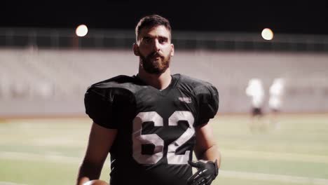 Portrait-of-a-football-player-on-a-field-catching-a-football