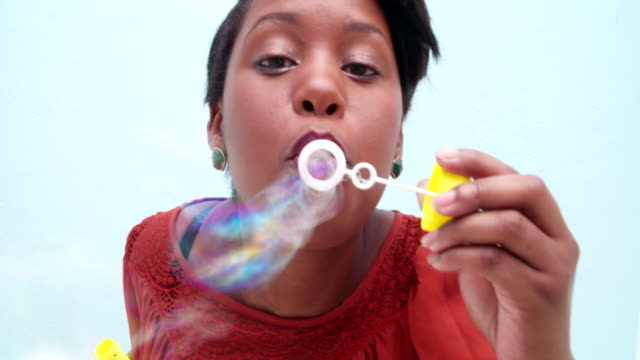Kindisch-junge-afrikanische-Frau-Blasen-Blasen