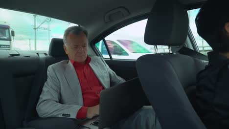 Portrait-male-working-on-the-computer-in-car