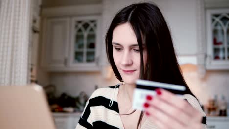 Attraktive-junge-lächelnde-Frau-verwendet-Kunststoff-Kreditkarte-online-shopping-mit-laptop