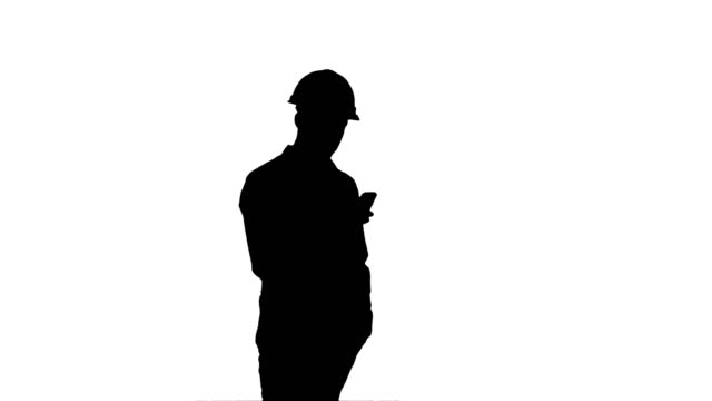 Silhouette-Young-manager-in-helmet-using-mobile-phone