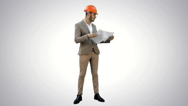 Young-architect-in-helmet-checking-construction-plans-on-white-background