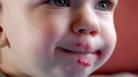An-attractive-boy-2-years-old-eats-a-red-beet-salad.-The-face-is-smeared-with-porridge.-Sits-on-the-table.-Close-up