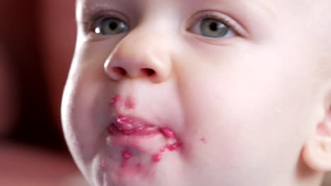 An-attractive-boy-2-years-old-eats-a-red-beet-salad.-The-face-is-smeared-with-porridge.-Sits-on-the-table.-Close-up