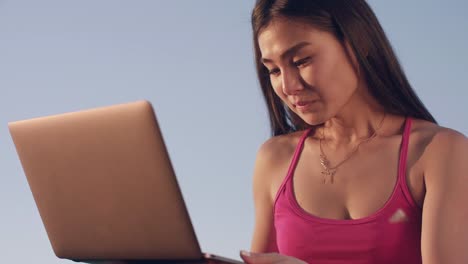 Mujer-asiática-con-el-exterior-del-ordenador-portátil.-Mujer-atractiva-usando-laptop