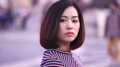sad-and-serious-Chinese-woman-turns-her-head-and-looks-at-the-camera