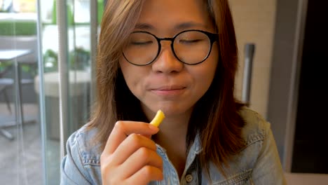 young-woman-eating-french-fries