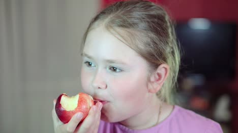 Caucasian-white-baby-eats-a-nectarine-and-smiling-at-the-camera.-4K