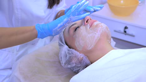 Beautician-cleans-the-woman's-face-in-a-beauty-salon