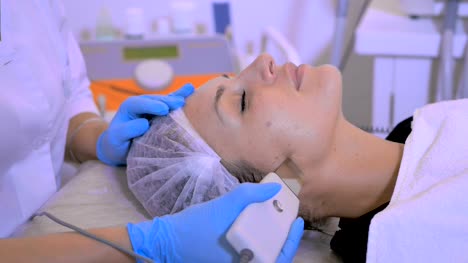 Kosmetikerin-macht-eine-Gesichtsbehandlung-Reinigung-mit-elektronischen-Geräten