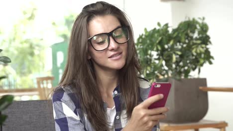 Mujer-usando-la-aplicación-smartphone-beber-café-sonriendo,-mensajes-de-texto-en-el-teléfono-móvil