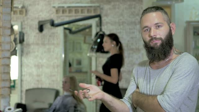Portrait-of-bearded-hairdresser-in-barbershop