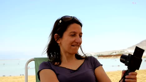 Lächelnde-Brünette-Frau-am-Strand-nimmt-ein-Selbstporträt