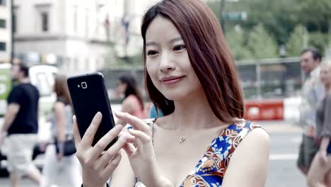 Hermosa-mujer-China-enviar-mensajes-de-texto-y-hablando-con-el-teléfono-en-la-ciudad.-Ser-feliz,-sonreír-y-divertirse.