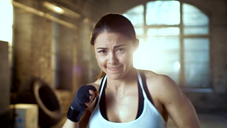 Beautiful-Athletic-Woman-Punches-Air-with-Her-Fists-as-Part-of-Her-Intensive-Cross-Fitness-Gym-Training.