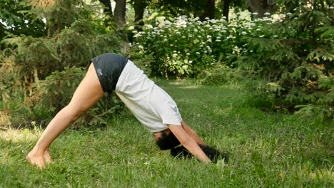 Pretty-woman-stretches-her-back-and-makes-sport-exercises-in-park