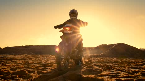 Tiro-de-ángulo-bajo-del-piloto-de-Motocross-profesional-sentado-en-su-moto-FMX-torsión-completa-del-acelerador-mango-y-empezando-a-montar-esta-pista-terreno-Off-Road-extremo