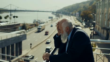 Hombre-senior-cansado-goza-de-un-tráfico-de-la-ciudad-desde-el-puente