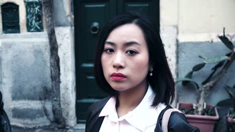 sad-serious-young-Asian-in-the-street-stares-at-the-camera
