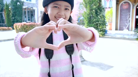 4K-Asian-little-girl-showing-hand-make-heart-shape-with-happiness-in-vacation-travel