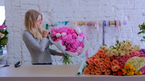 Floreria-envuelve-flores-en-papel-de-regalo-en-la-tienda-de-la-flor