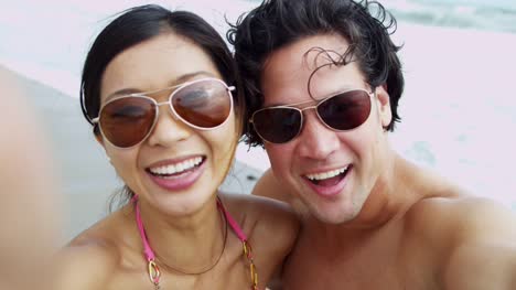 Portrait-Asian-Chinese-young-couple-sunglasses-filming-selfie
