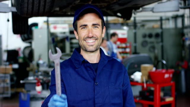 Portrait-of-a-young-beautiful-car-mechanic-in-a-car-workshop,-in-the-background-of-service.-Concept:-repair-of-machines,-fault-diagnosis,-repair-specialist,-technical-maintenance-and-on-board-computer