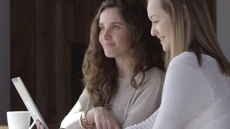 Zwei-junge-Frauen-im-Café-unter-Selfies-zusammen-mit-digital-Tablette