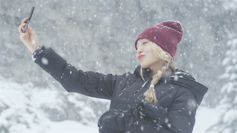 Toma-de-retrato-de-una-bella-mujer-asiática-joven-tomando-un-selfie-en-un-día-de-nieve