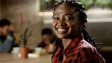Portrait-of-smiling-black-woman-in-cafe