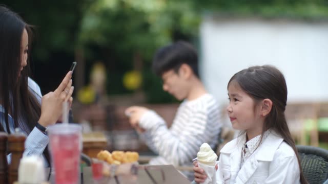 Kleines-Mädchen-posiert-mit-Eis-bei-Smartphone-Kamera