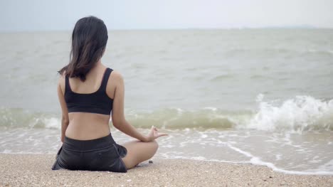 Joven-de-asia-practicando-yoga-en-el-beach.4K-resolución