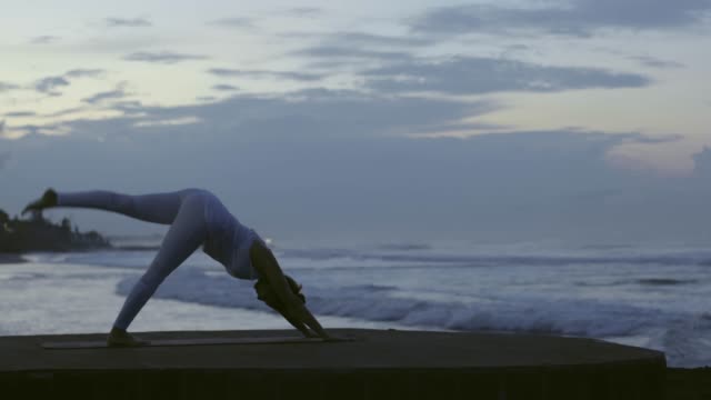 Woman-Doing-Standing-Split-Pose-on-Beach