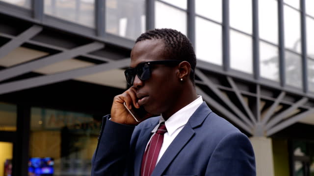 Gerente-africano-negro-seguro-ocupada-hablando-por-teléfono-en-el-street