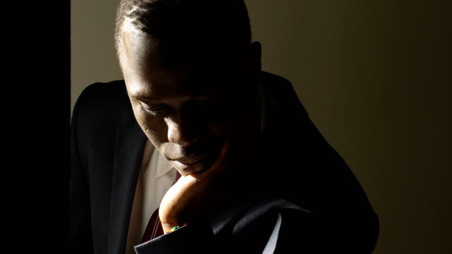 Thoughtful-worried-young-black-business-man-in-the-dark