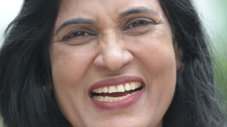 Close-up-shot-of-mature-happy-beautiful-Indian-woman-smiling-in-the-streets-outdoors
