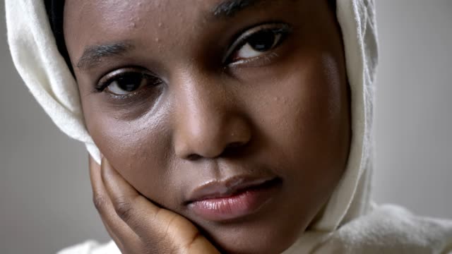 Gesicht-Ofoung-trauriges-afrikanischen-muslimisches-Mädchen-Hijab-ist-gerade-in-die-Kamera,-Religioun-Konzept,-grauen-Hintergrund