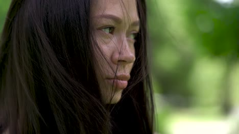 Un-retrato-de-una-mujer-asiática-triste.-Viento-desarrolla-a-su-pelo.-Desesperanza-y-depresión-en-sus-ojos.