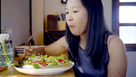 Mujeres-asiáticas-feliz,-comer-ensaladas-en-restaurantes.