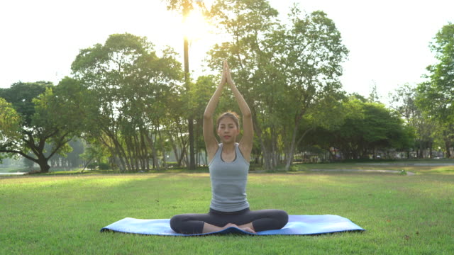 Mujer-asiática-joven-yoga-al-aire-libre-mantenga-la-calma-y-medita-mientras-practicaba-yoga-para-explorar-la-paz-interior.-Yoga-y-la-meditación-tienen-beneficios-para-la-salud.-Yoga-deporte-y-sano-concepto-de-estilo-de-vida.