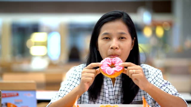 Asiatische-Frauen-sind-gerne-Donuts-Essen.