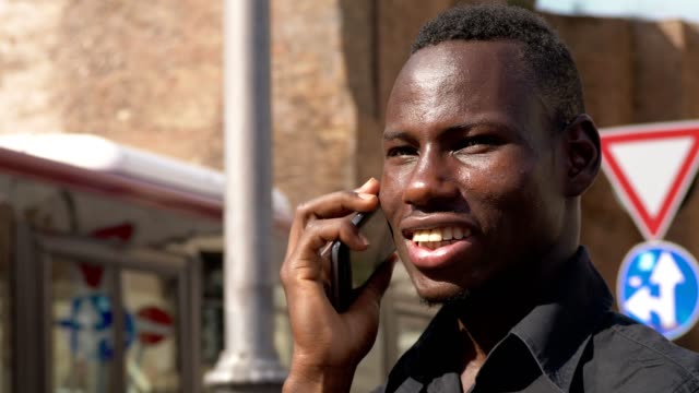 lächelnd,-glücklich-junge-Afrikaner-sprechen-von-Telefon---outdoor