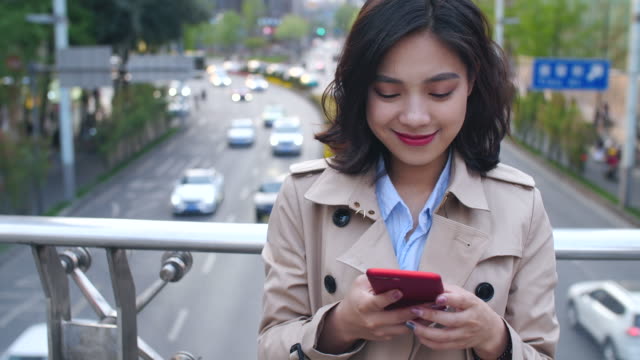 Mujer-joven-usando-teléfono-inteligente-en-la-ciudad