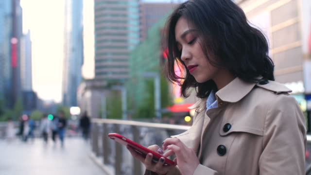 young-asian-woman-using-smartphone-in-the-city