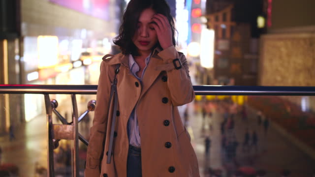 Slow-Motion-für-eine-hübsche-junge-Asiatin-berühren-ihr-Haar-in-der-Stadt-bei-Nacht