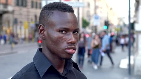 Thoughtful-daydreaming-young-american-african-man-in-the-street,looking-camera